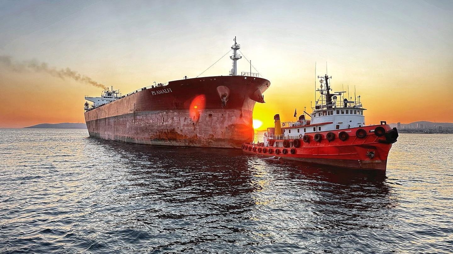 Ocean Ergun römorkörü gün batımında büyük bir geminin bordasında
